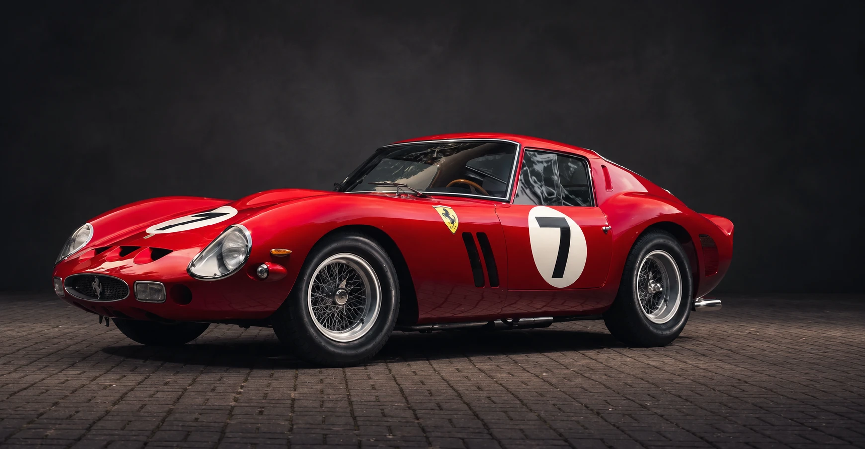 Ferrari d'epoca rossa con il numero 7 in uno studio scuro